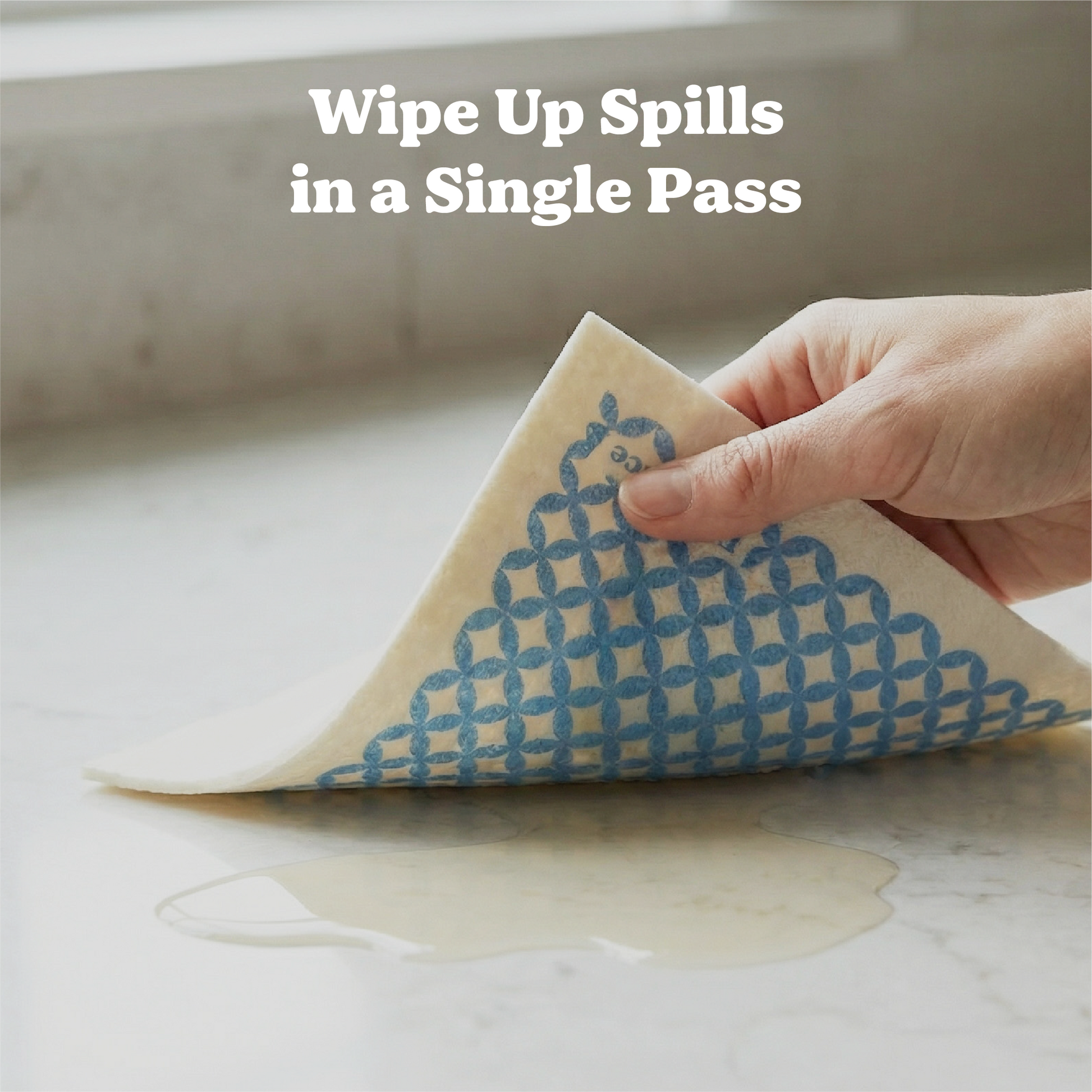 Hand using a pronounce dish cloth to wipe up a spill on a surface in a single pass